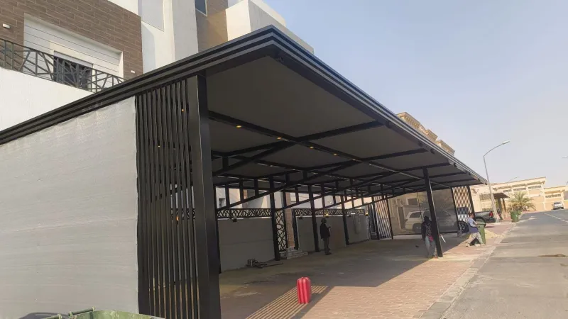 حداد مظلات الكويت - تركيب برجولة خشبية مع خلفية حجرية وإضاءة من Kuwait Haddat